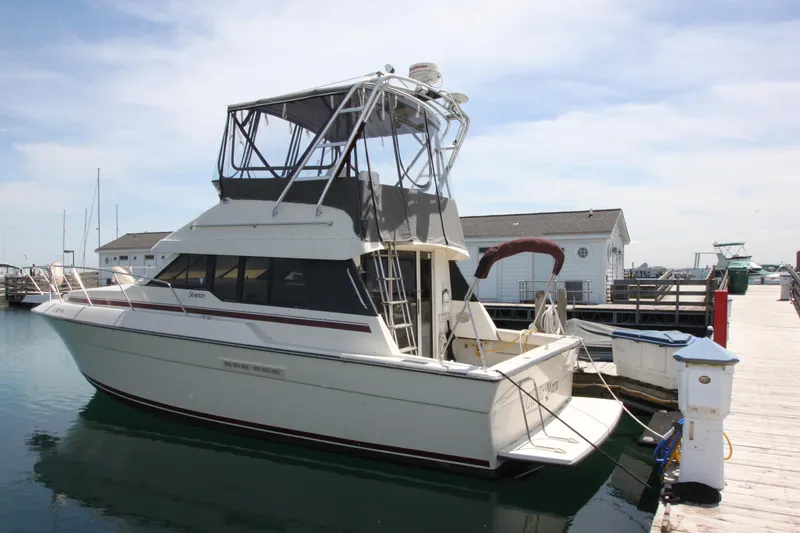 Slide: The Image of 1990 Silverton 34 Convertible boat docked at a marina under a clear sky. - 1