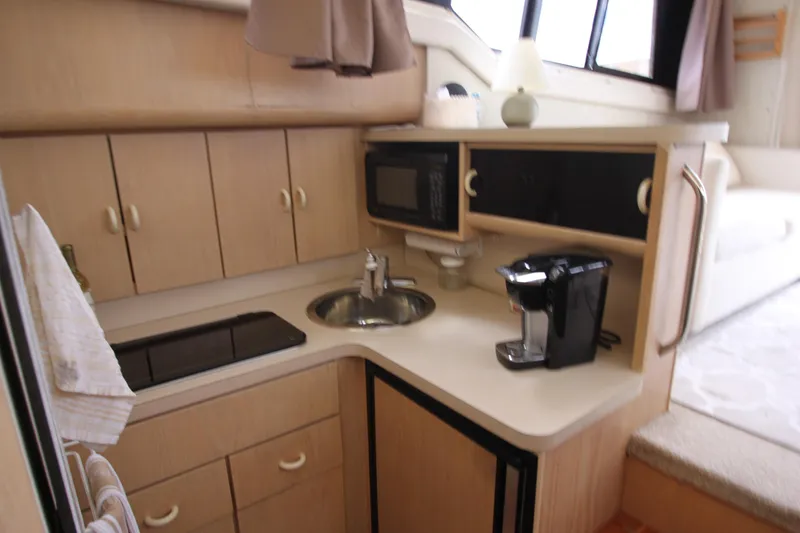 Slide: The Image of Compact kitchen in 1990 Silverton 34 Convertible yacht with sink, microwave, and coffee maker. - 31