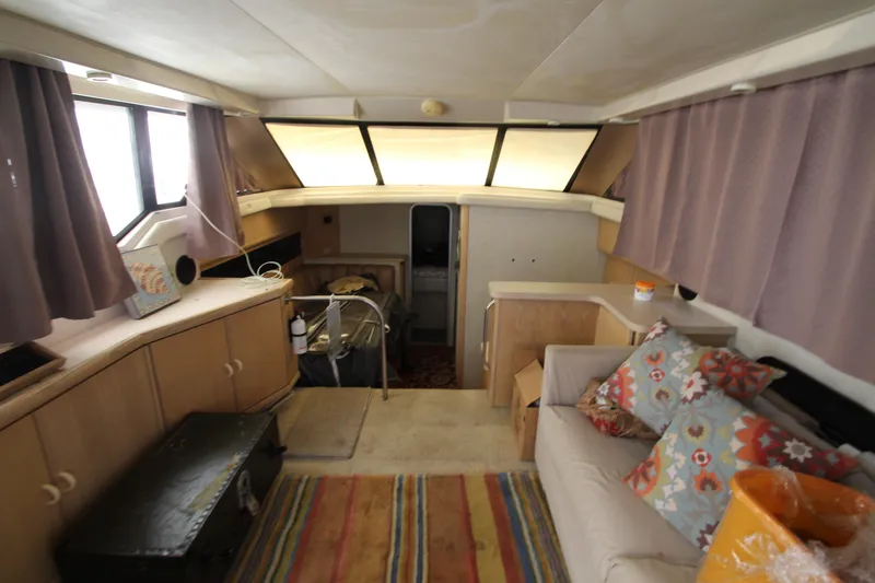Slide: The Image of Interior of 1990 Silverton 34 Convertible boat with cozy seating and colorful decor. - 49