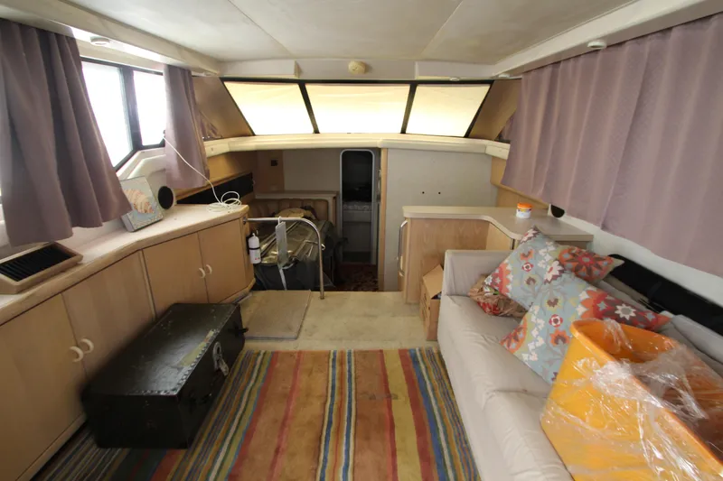 Slide: The Image of Interieur van een Silverton 34 Convertible uit 1990 met bank, kleed en gordijnen. - 50