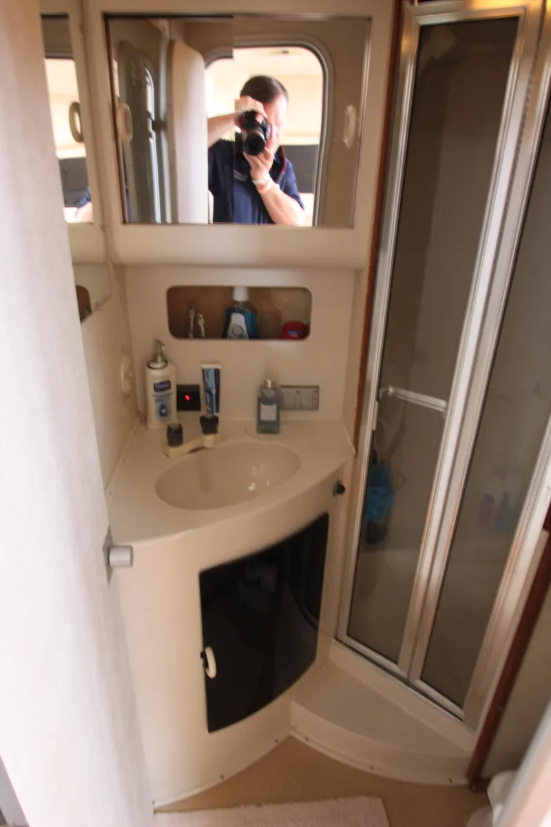 Slide: The Image of 1990 Silverton 34 Convertible bathroom with shower, sink, and mirror. - 24