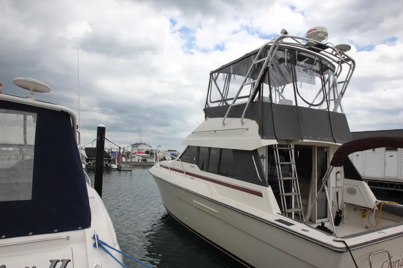Slide: The Image of 1990 Silverton 34 Convertible yacht docked at marina under cloudy sky. - 3