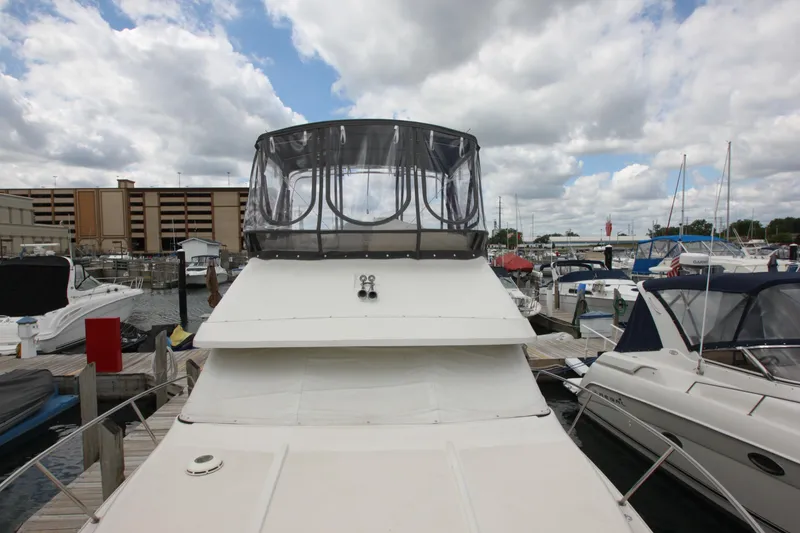 Slide: The Image of 1990 Silverton 34 Convertible yacht docked at a marina under cloudy skies. - 10