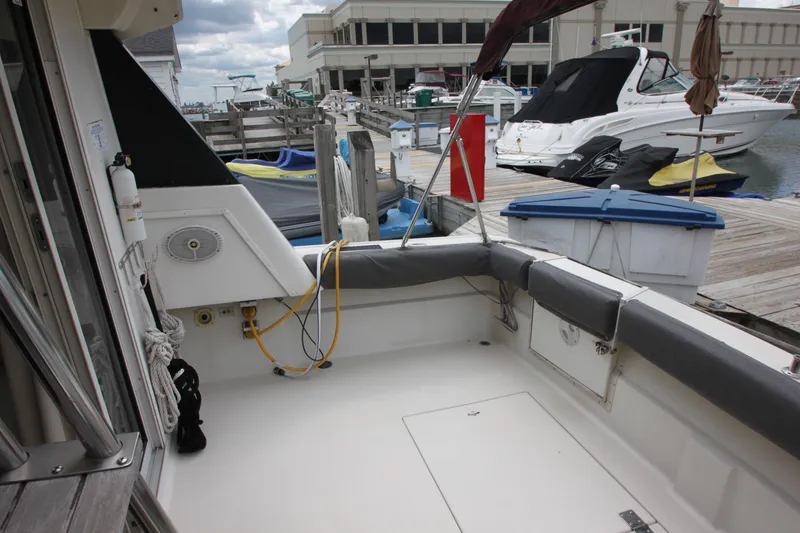 Slide: The Image of 1990 Silverton 34 Convertible boat docked at marina, featuring spacious deck area. - 35