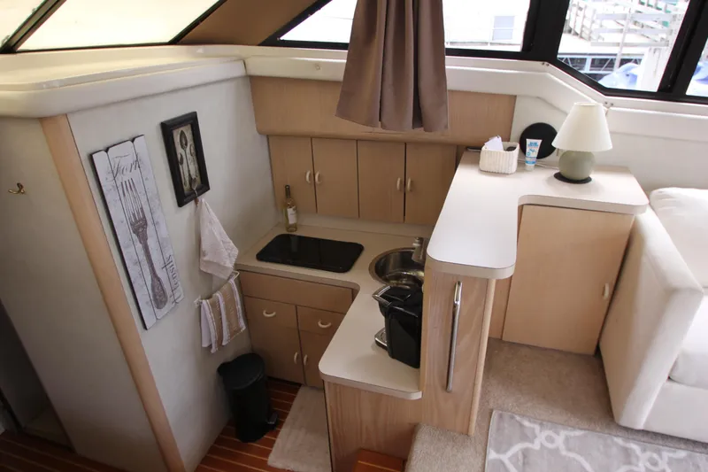 Slide: The Image of Compact kitchen area in a 1990 Silverton 34 Convertible yacht, featuring modern amenities. - 17