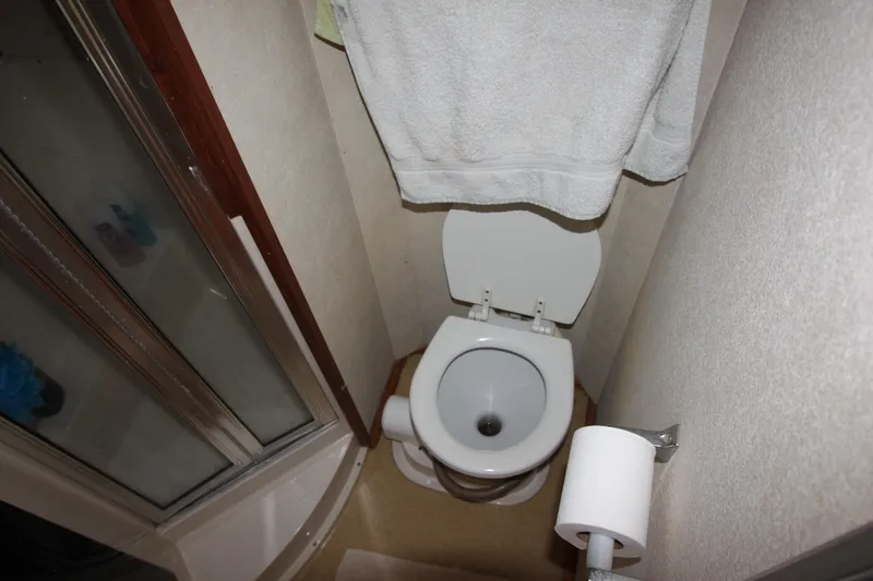 Slide: The Image of Bathroom interior of 1990 Silverton 34 Convertible yacht, featuring toilet and shower. - 27