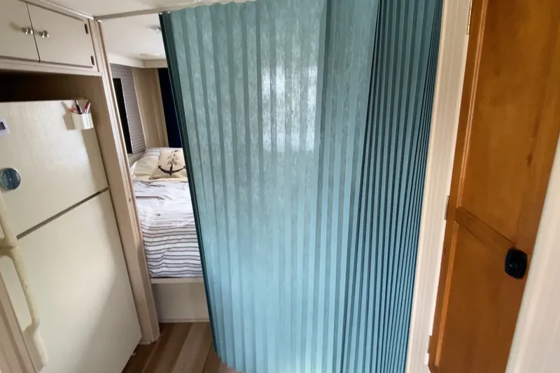 Slide: The Image of Interior of 2000 Gibson 37 Sport Series with blue curtain and cozy bedroom. - 21