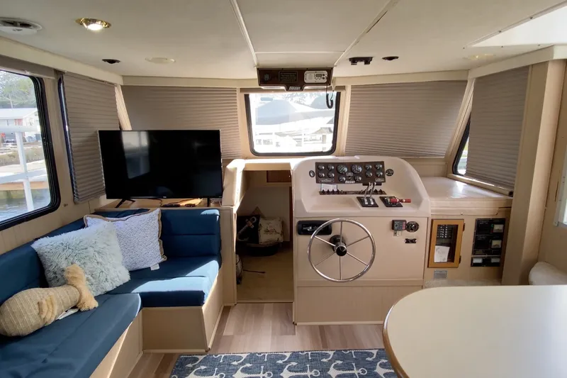 Slide: The Image of Interior of 2000 Gibson 37 Sport Series boat with helm, seating, and TV. - 18