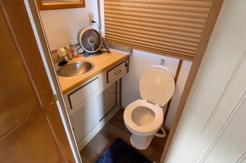 Slide: The Image of Compact bathroom in a 2000 Gibson 37 Sport Series boat, featuring a sink and toilet. - 22