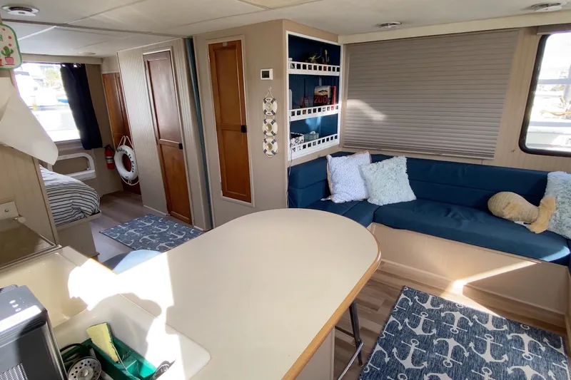 Slide: The Image of Interior of a 2000 Gibson 37 Sport Series boat with cozy seating and nautical decor. - 14