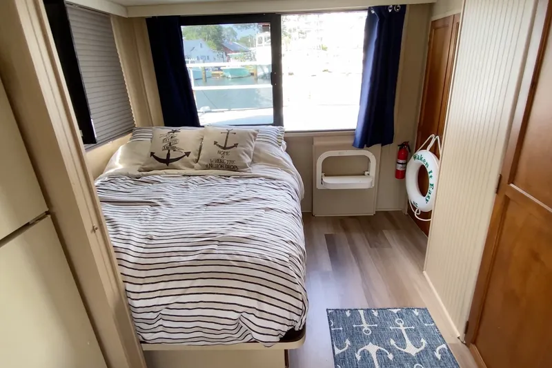 Slide: The Image of Cozy bedroom in 2000 Gibson 37 Sport Series boat with nautical decor and striped bedding. - 19