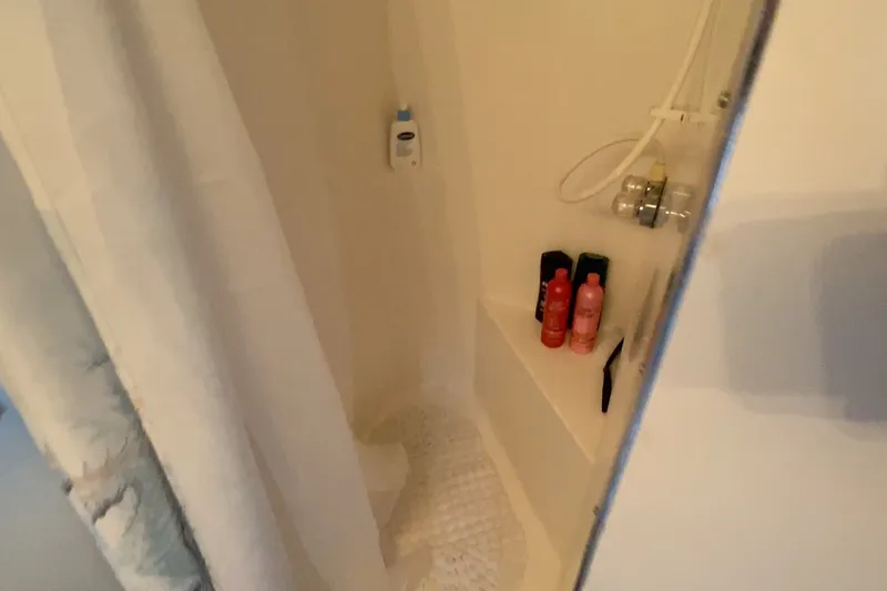 Slide: The Image of Shower area in a 2000 Gibson 37 Sport Series boat with toiletries and curtain. - 23