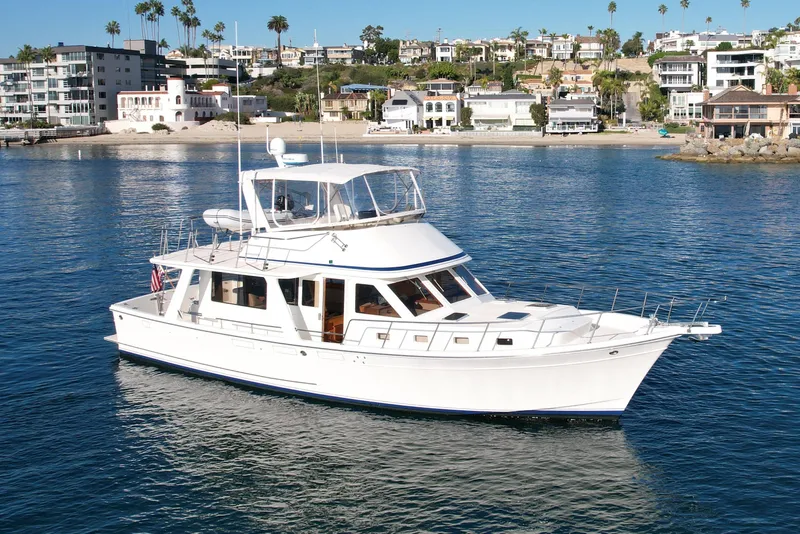 Slide: The Image of 1997 Offshore Yachts 48 Sedan cruising near coastal homes. - 2