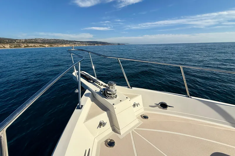 Slide: The Image of Bow view of 1997 Offshore Yachts 48 Sedan cruising on open sea. - 56