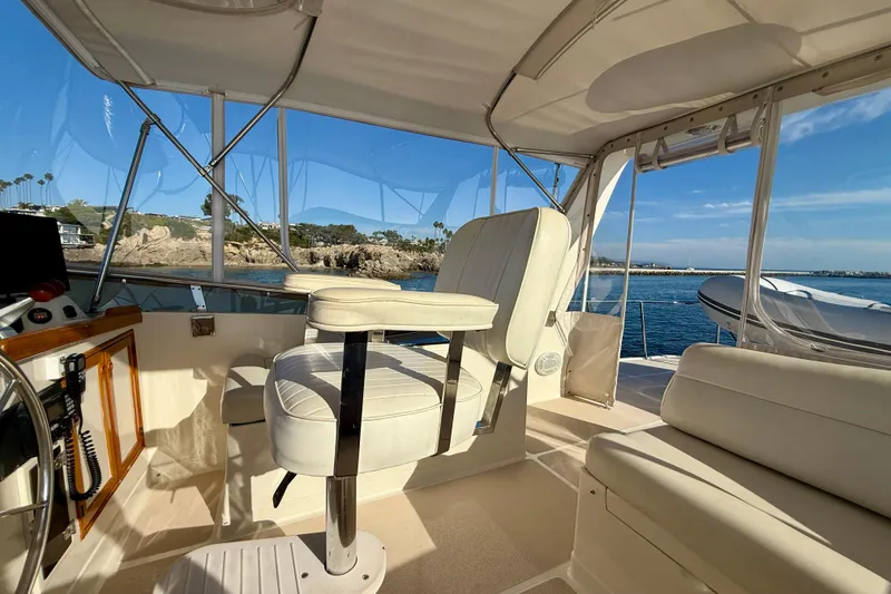 Slide: The Image of Interior view of 1997 Offshore Yachts 48 Sedan, featuring helm and seating area. - 82
