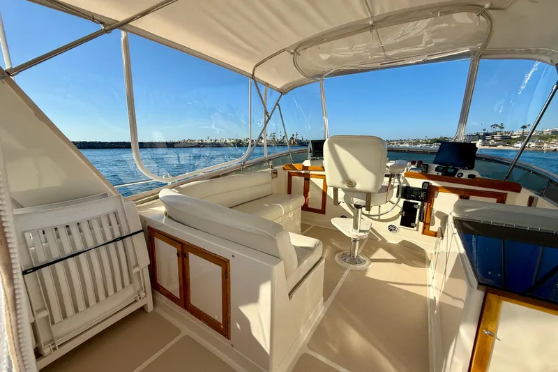 Slide: The Image of 1997 Offshore Yachts 48 Sedan interior with helm, seating, and ocean view. - 76