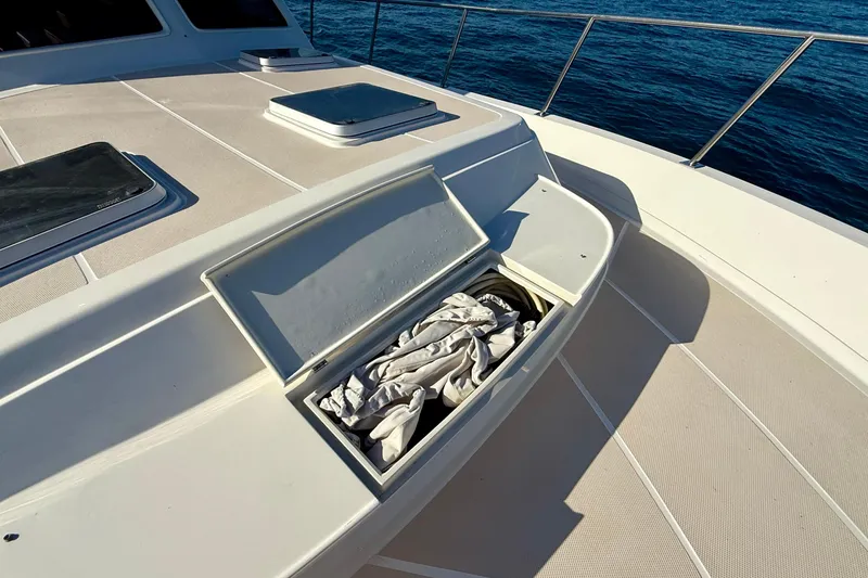 Slide: The Image of Deck storage compartment on a 1997 Offshore Yachts 48 Sedan, open with fabric inside. - 59