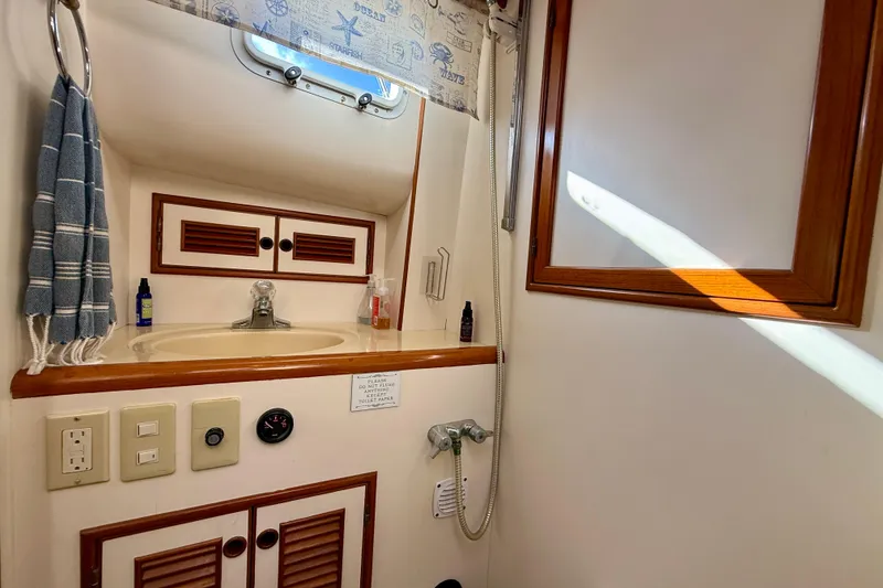 Slide: The Image of Bathroom interior of 1997 Offshore Yachts 48 Sedan with sink and wooden accents. - 26