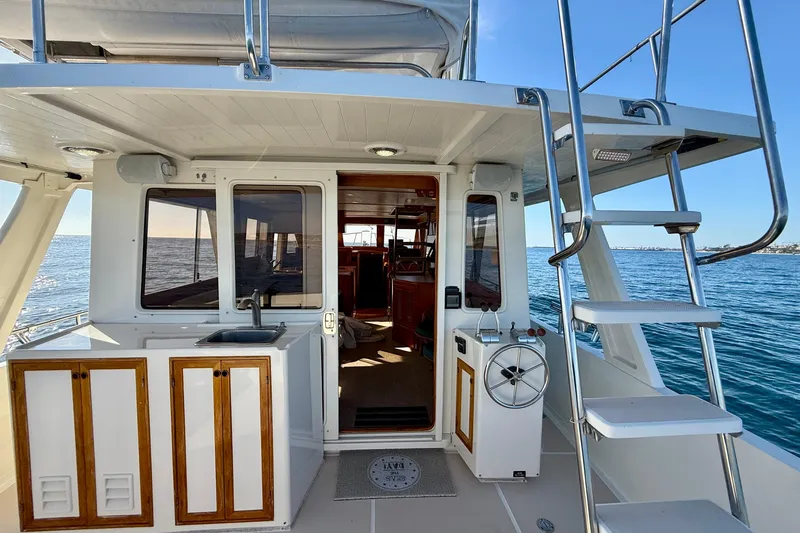 Slide: The Image of 1997 Offshore Yachts 48 Sedan, rear deck view with ocean backdrop and ladder. - 64