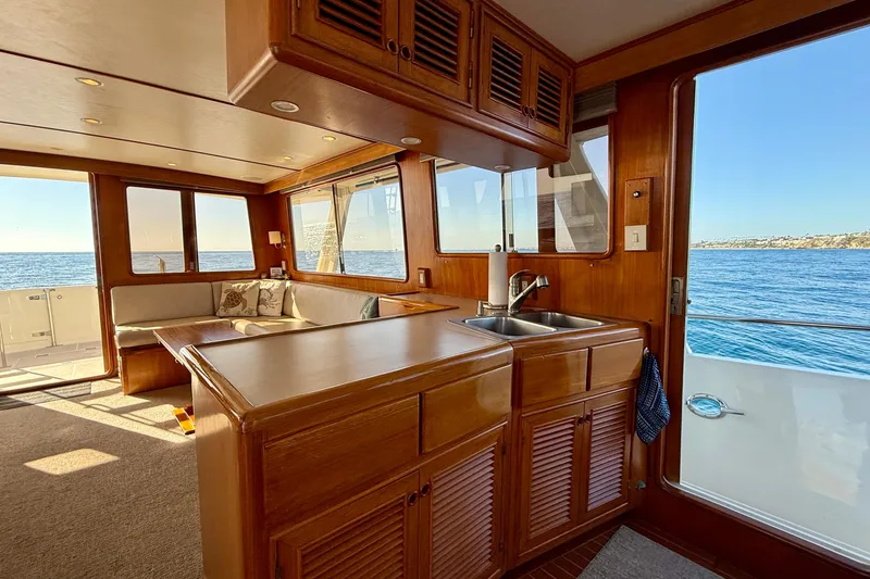 Slide: The Image of Interior of 1997 Offshore Yachts 48 Sedan with ocean view and wooden cabinetry. - 49