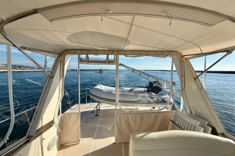 Slide: The Image of 1997 Offshore Yachts 48 Sedan interior view with ocean backdrop and inflatable boat. - 78