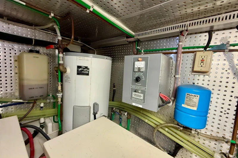 Slide: The Image of Engine room of 1997 Offshore Yachts 48 Sedan with water heater and battery charger. - 87