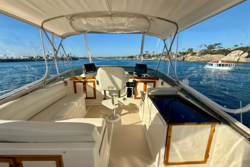 Slide: The Image of 1997 Offshore Yachts 48 Sedan interior with helm, seating, and ocean view. - 77