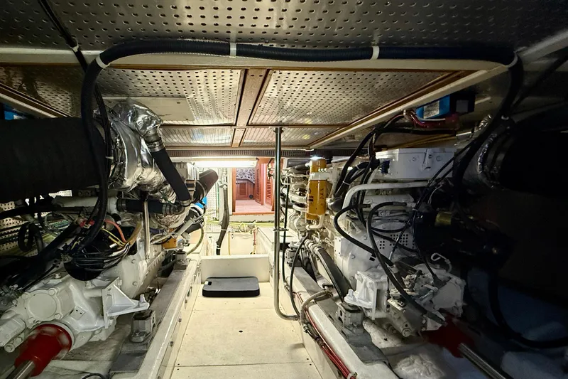 Slide: The Image of Engine room of a 1997 Offshore Yachts 48 Sedan, showcasing mechanical components and wiring. - 85