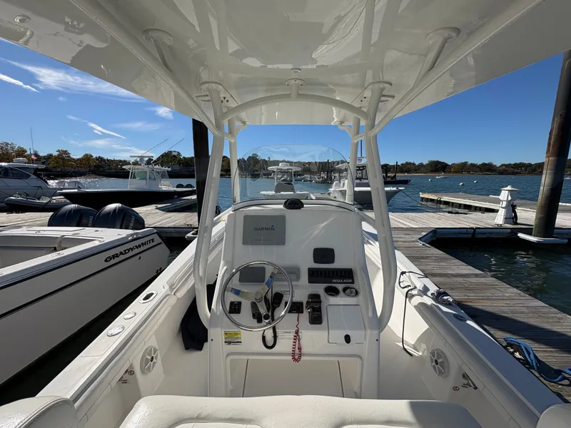 Slide: The Image of The image shows the cockpit of a Regulator 23 boat docked at a marina. - 13