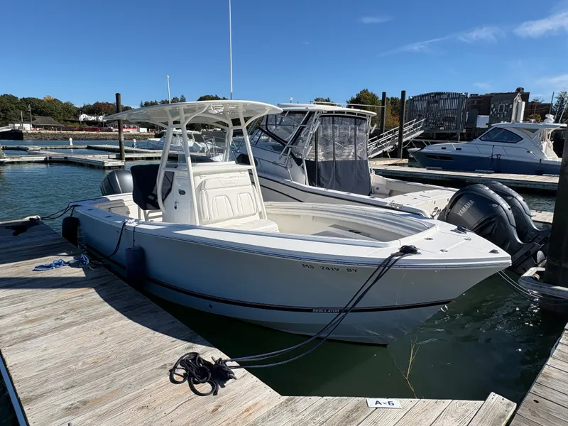 Slide: The Image of A 2017 Regulator 23 boat docked. It features a white deck and a canopy. - 5