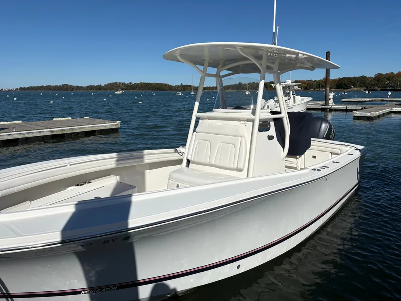 Slide: The Image of A white 2017 Regulator 23 boat docked on calm water. - 3