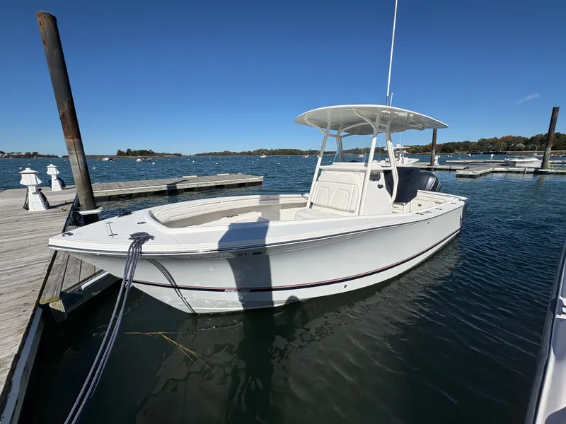 Slide: The Image of A white 2017 Regulator 23 boat docked in calm waters. - 2