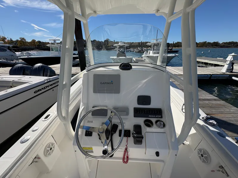 Slide: The Image of The image shows the helm of a 2017 Regulator 23 boat docked at a marina. - 14