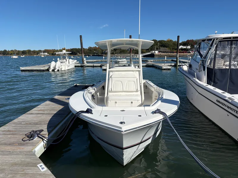 Slide: The Image of A 2017 Regulator 23 boat docked. It features a T-top and is white. - 4