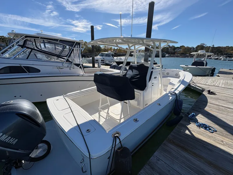 Slide: The Image of A 2017 Regulator 23 boat docked. It features a T-top and a Yamaha engine. - 6
