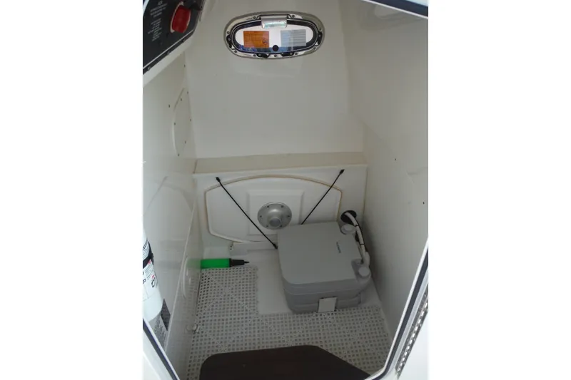 Slide: The Image of 2020 Boston Whaler 270 Dauntless interior cabin with portable toilet and storage. - 40