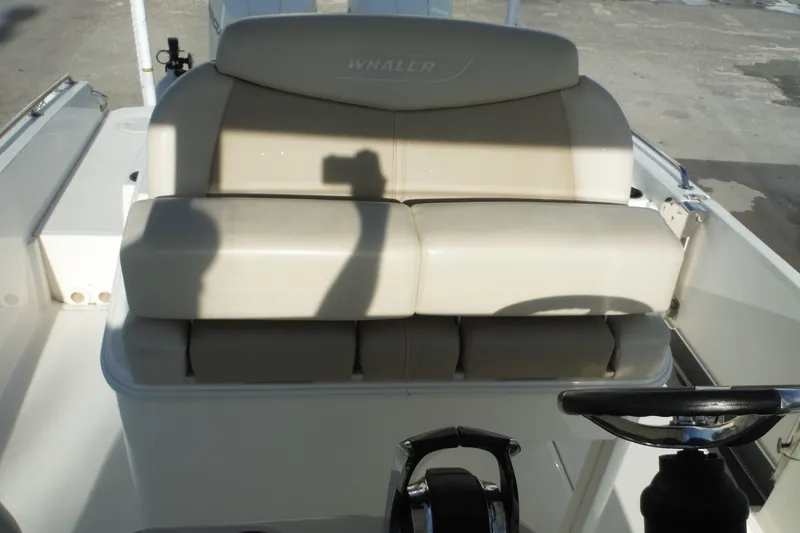 Slide: The Image of 2020 Boston Whaler 270 Dauntless boat seating area with steering wheel visible. - 36