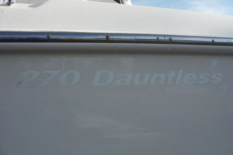 Slide: The Image of 2020 Boston Whaler 270 Dauntless boat nameplate with chrome rail detail. - 13