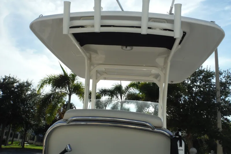 Slide: The Image of Boston Whaler 270 Dauntless 2020 boat with T-top, viewed from below, palm trees in background. - 17