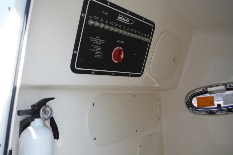 Slide: The Image of Control panel and fire extinguisher inside 2020 Boston Whaler 270 Dauntless boat. - 39