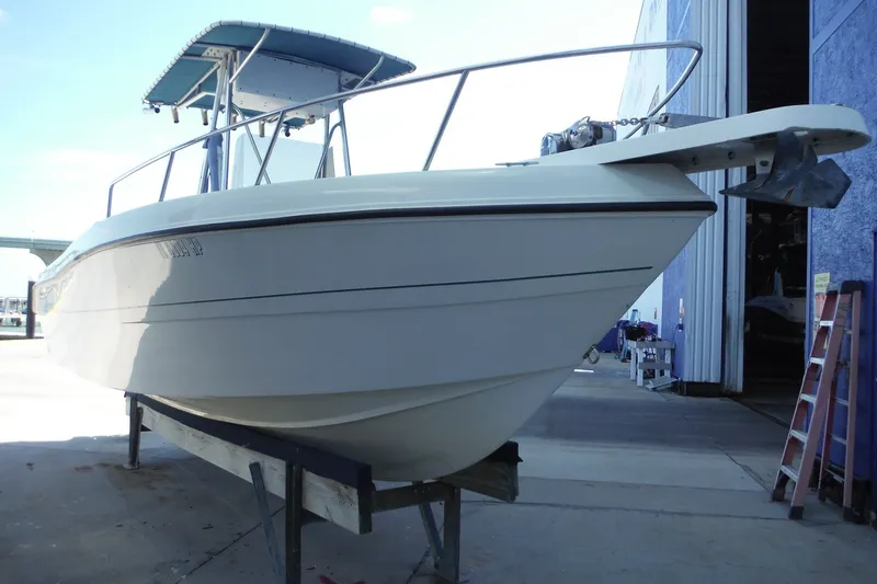The Image of 1999 Pro Sports 2200 CC boat on a stand near a blue building. - 0