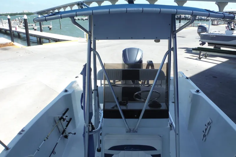 Slide: The Image of 1999 Pro Sports 2200 CC boat at dock, featuring center console and fishing rods. - 12