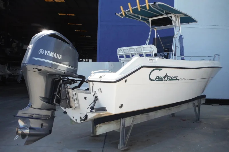 Slide: The Image of 1999 Pro Sports 2200 CC boat with Yamaha outboard motor, docked indoors. - 32