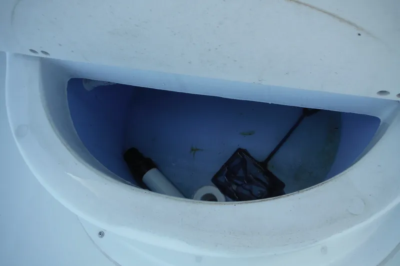 Slide: The Image of Open storage compartment in 1999 Pro Sports 2200 CC boat, containing various items. - 19