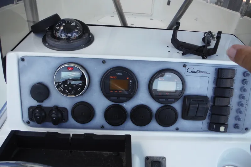 Slide: The Image of Control panel of a 1999 Pro Sports 2200 CC boat with gauges and switches. - 14