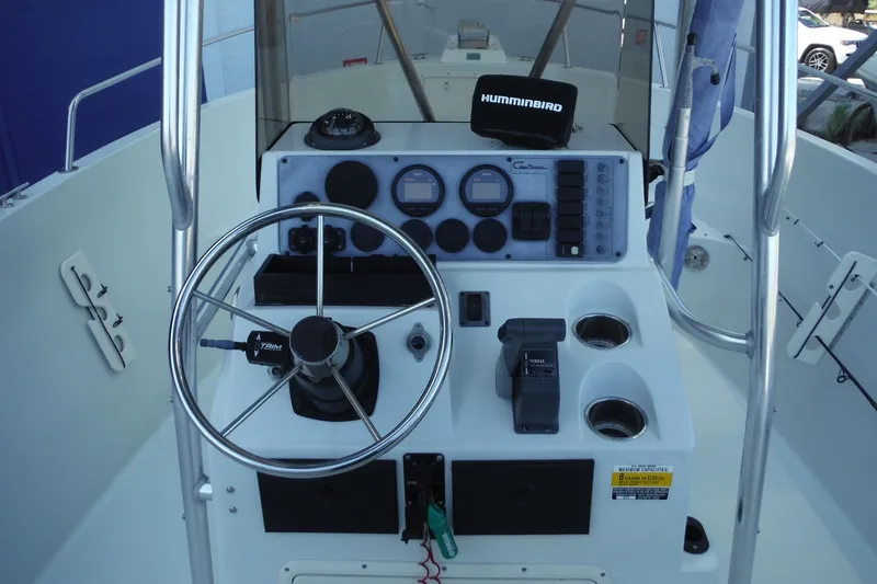 Slide: The Image of Center console of a 1999 Pro Sports 2200 CC boat with steering wheel and controls. - 21