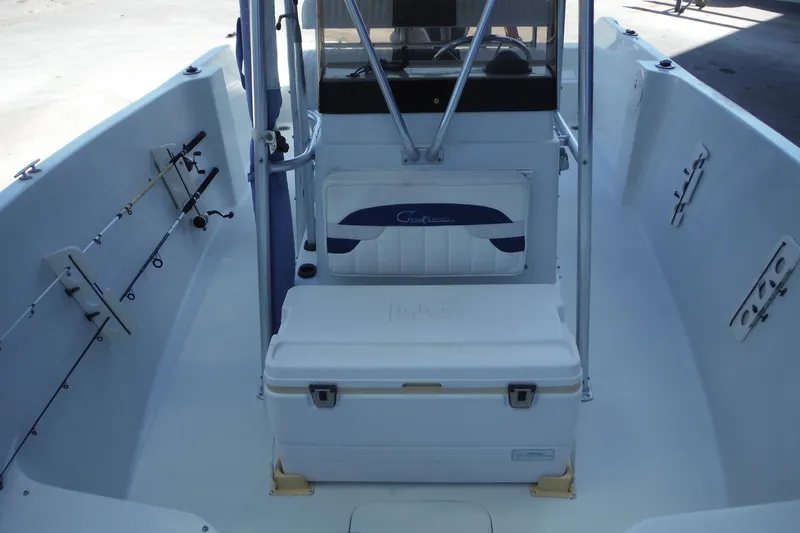 Slide: The Image of 1999 Pro Sports 2200 CC boat interior with fishing rod holders and cooler. - 13