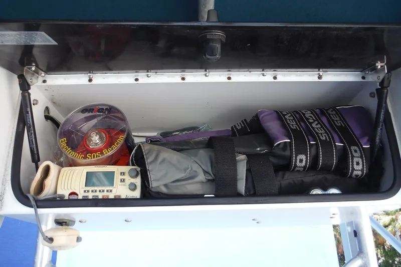 Slide: The Image of Storage compartment with electronic SOS beacon, radio, and safety gear on a 1999 Pro Sports 2200 CC boat. - 17