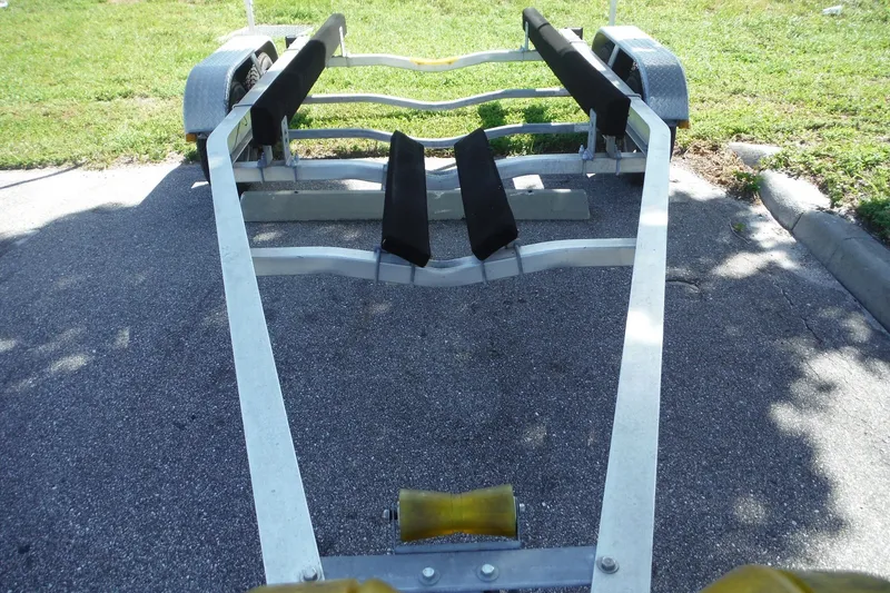 Slide: The Image of Boat trailer for Pro Sports 2200 CC, 1999 model, parked on asphalt near grass. - 36