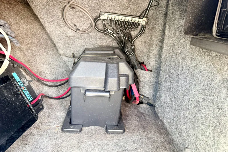 Slide: The Image of 2014 Nautique Super Air Nautique 210 battery compartment with wiring and connections. - 51
